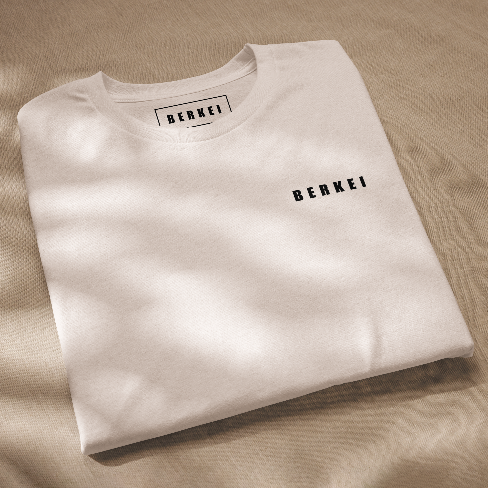 Beiges BERKEI Unisex Bio-T-Shirt Mountain auf einem hellen Untergrund
