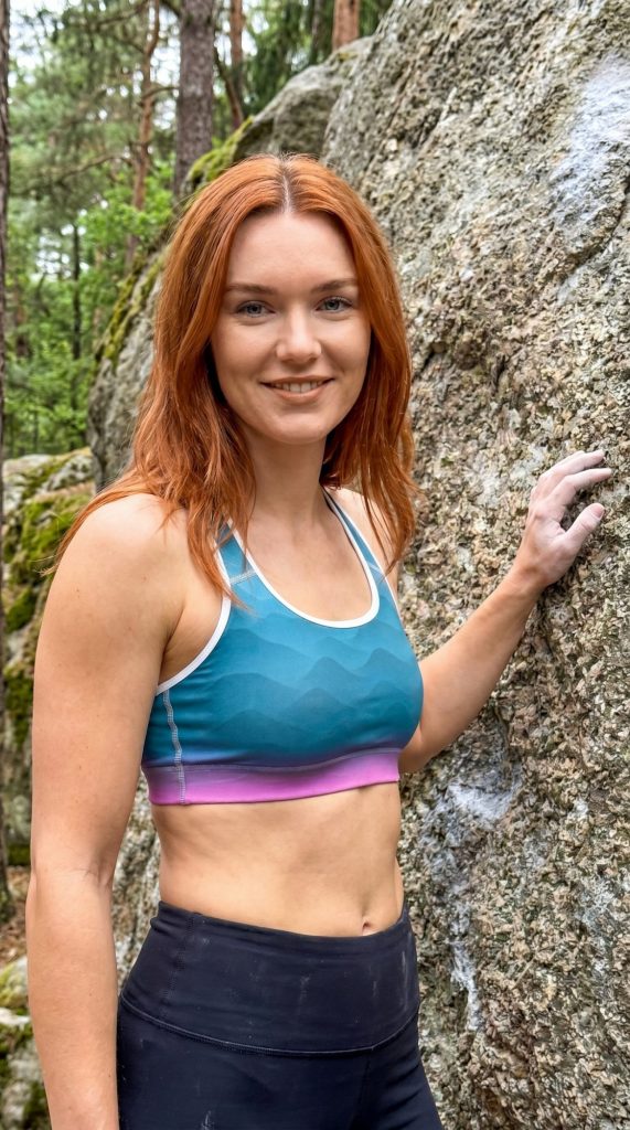 Frau trägt gepolsterten BERKEI Sport-BH Fountain Blue beim Klettern in der Natur