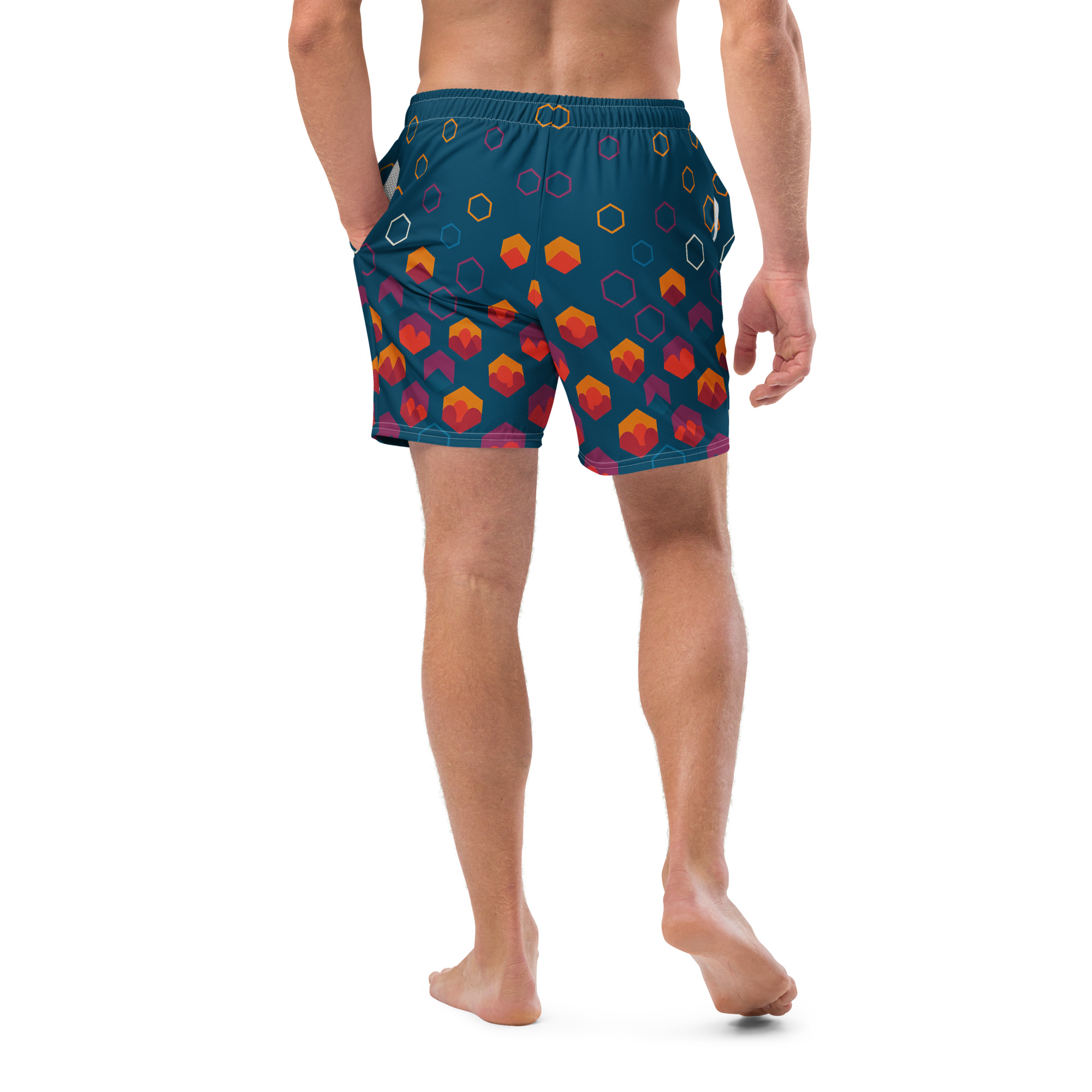 Männliche Person trägt die BERKEI Badehose Night Gear mit buntem Muster am Strand.