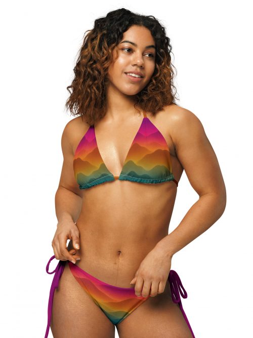 Frau trägt den farbenfrohen BERKEI Bikini Forest Sunrise mit Berglandschaftsdesign