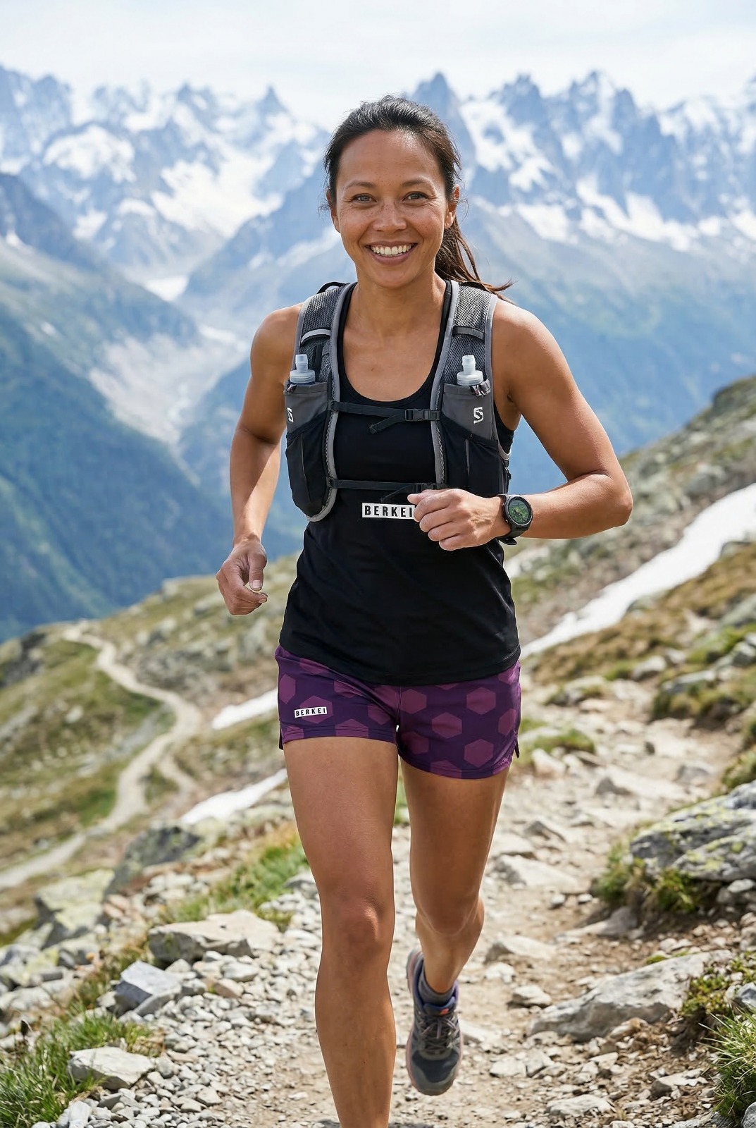 Frau in lila BERKEI Performance Shorts beim Laufen in den Bergen