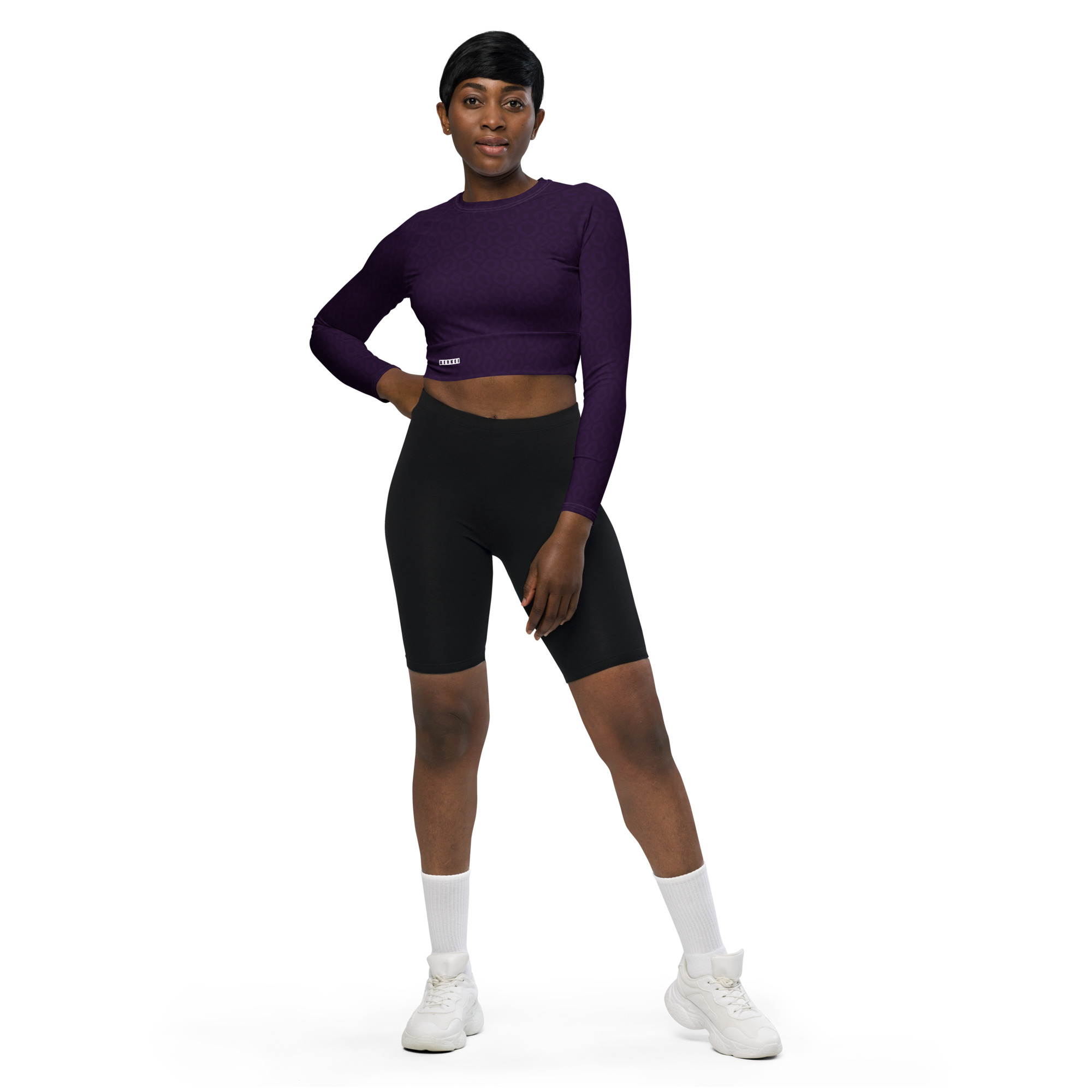 Dame trägt das BERKEI Recycelte Langarm Crop Top Purple Leo in sportlicher Pose.