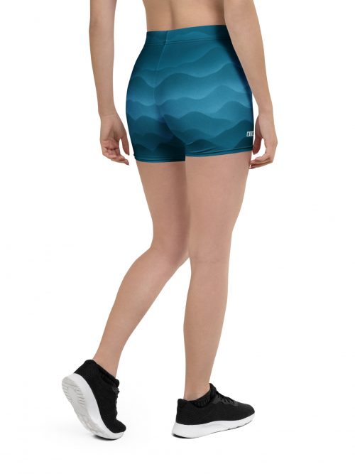 Frau trägt BERKEI Shorts Fountain Blue mit wellenförmigem Design von hinten