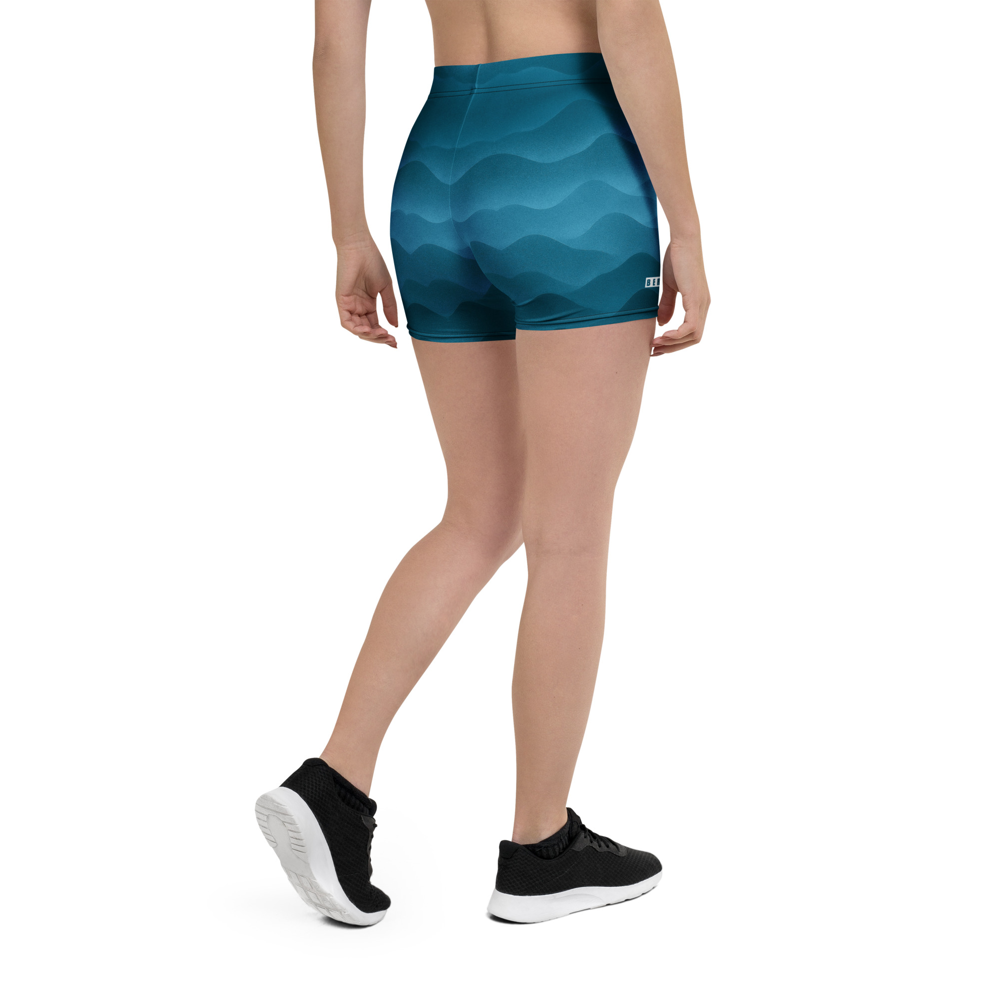 Frau trägt BERKEI Shorts Fountain Blue mit wellenförmigem Design von hinten