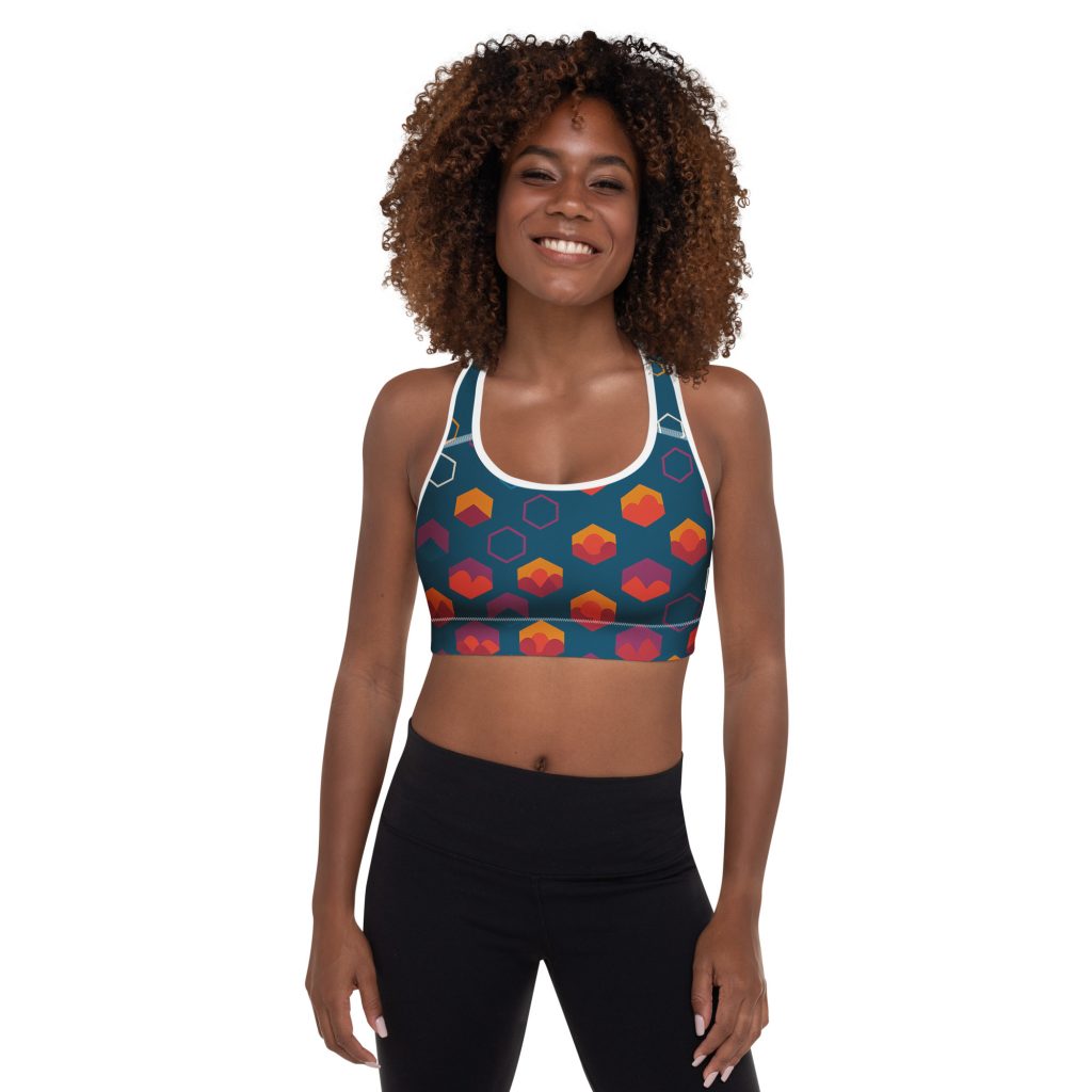 Sportliche Frau trägt den gepolsterten BERKEI Sport-BH Night Gear in buntem Design während des Trainings