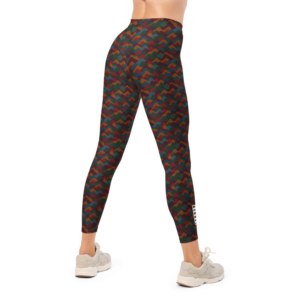 Frau trägt BERKEI Trail Leggings Indian Summer mit buntem Muster für Outdoor-Aktivitäten.