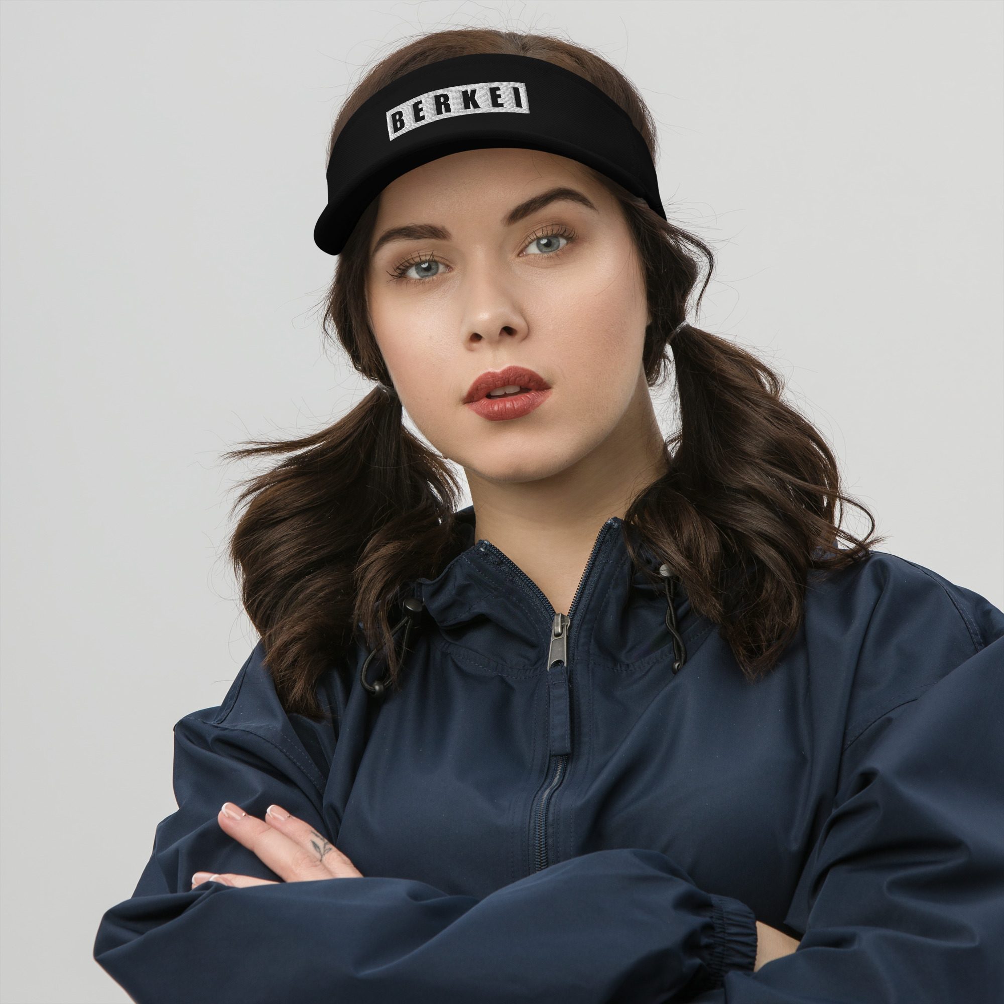 BERKEI Visor Black, sportliches Visier mit markantem Logo, getragen von junger Frau.