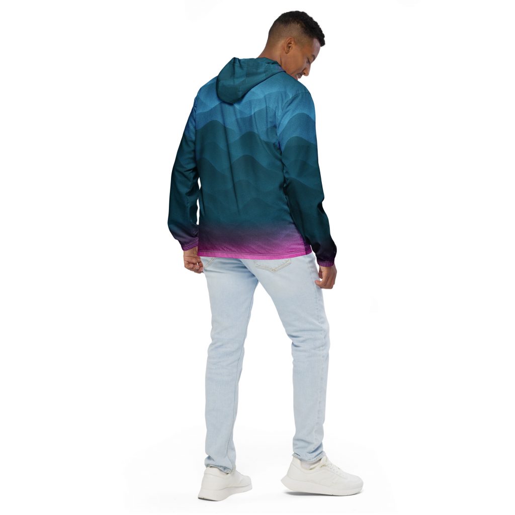 Mann trägt den BERKEI Windbreaker Fountain Blue mit einem bunten, abstrakten Design.