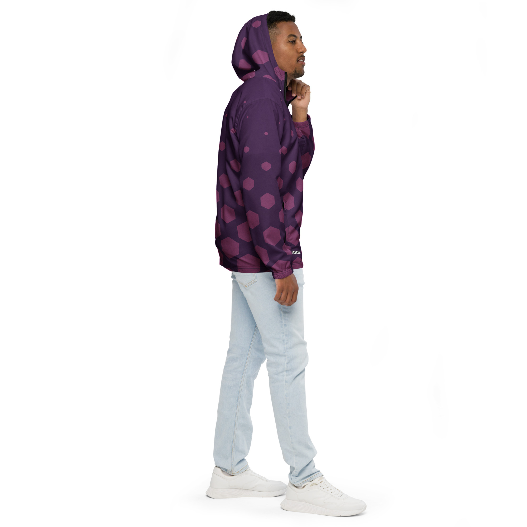 Mann trägt BERKEI Windbreaker Purple Gear mit Punkten und Kapuze in sportlicher Pose