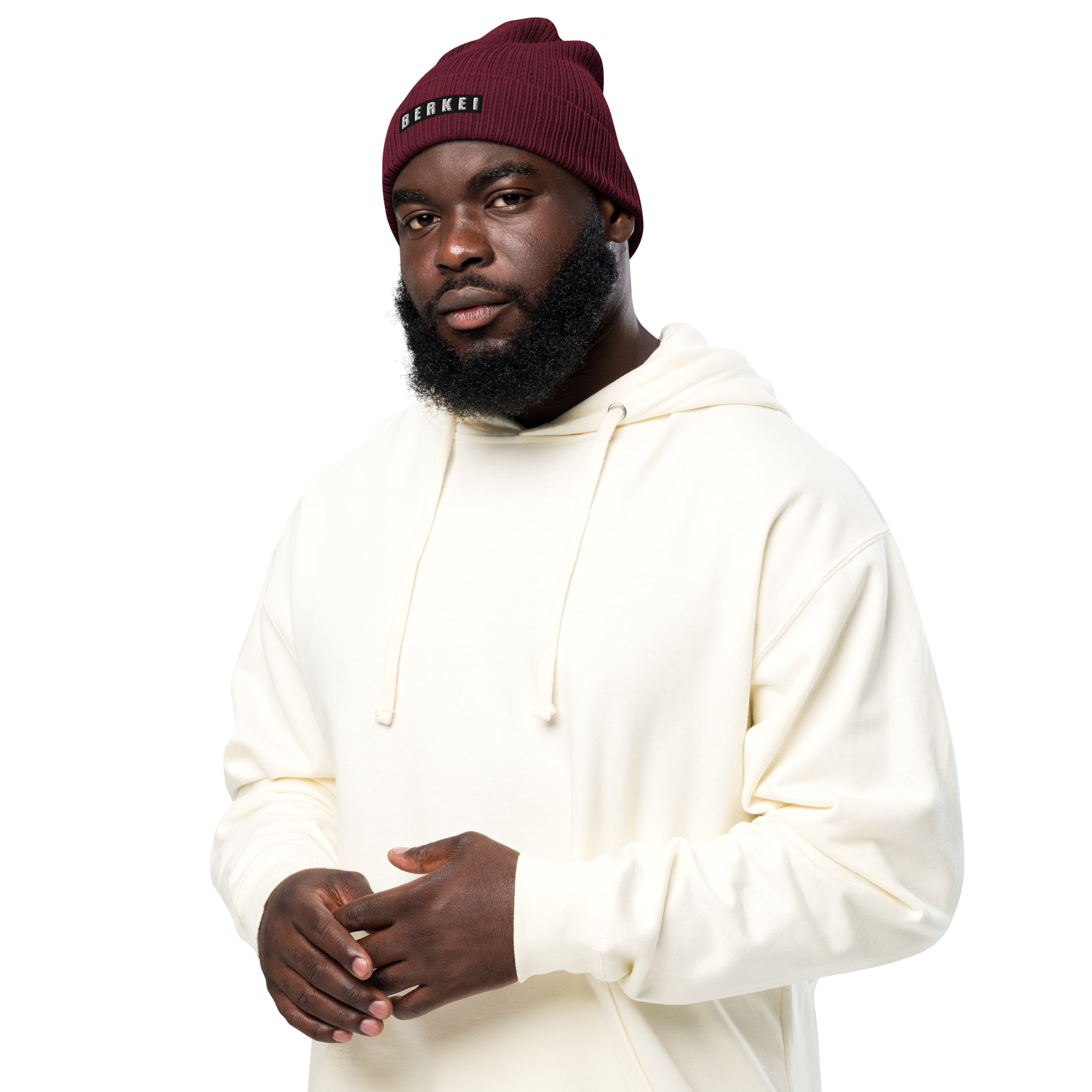 Rote BERKEI Strickmütze aus Bio-Material, der model trägt sie lässig zusammen mit einem Hoodie.