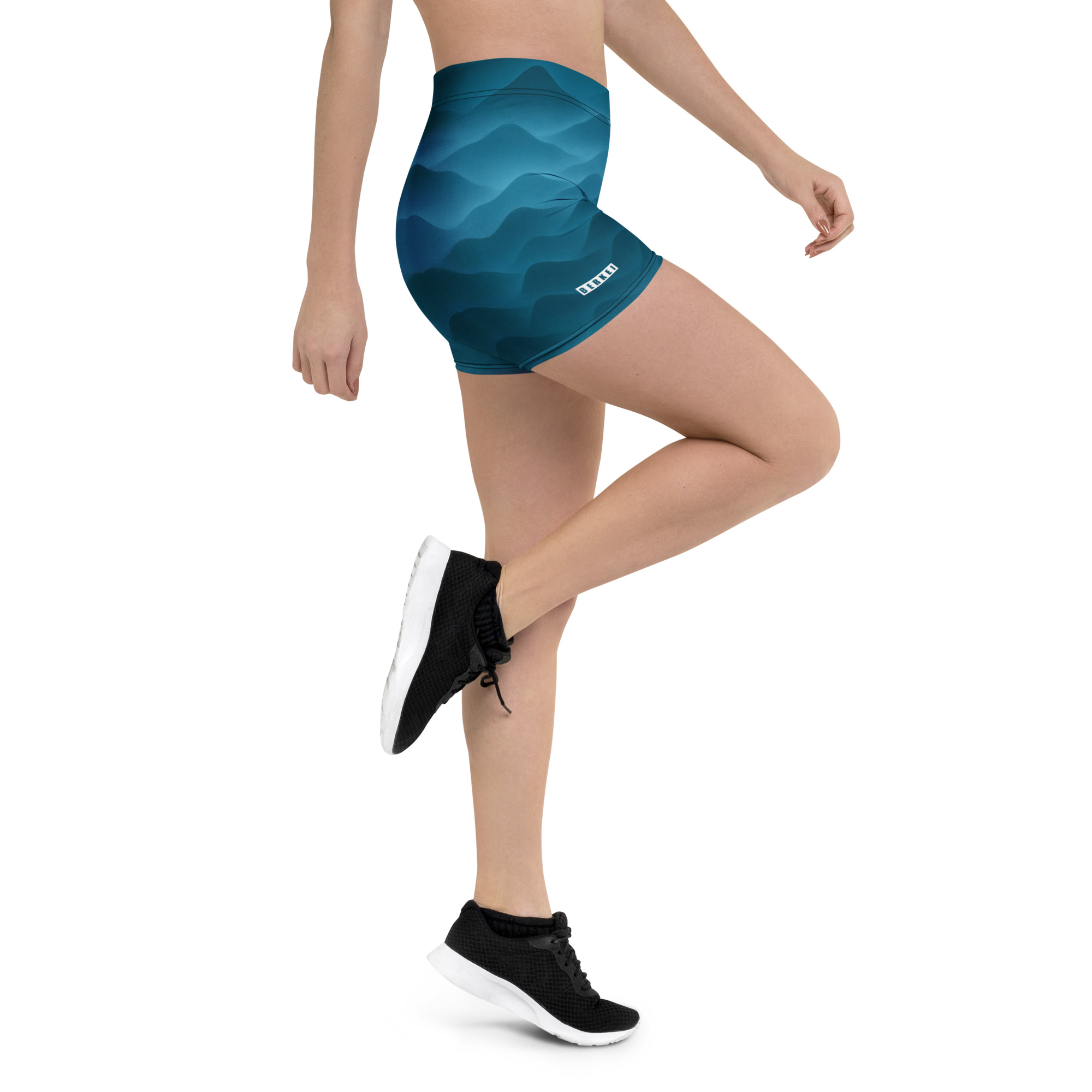 Dame trägt BERKEI Shorts Fountain Blue mit wellenförmigem Muster beim Sport
