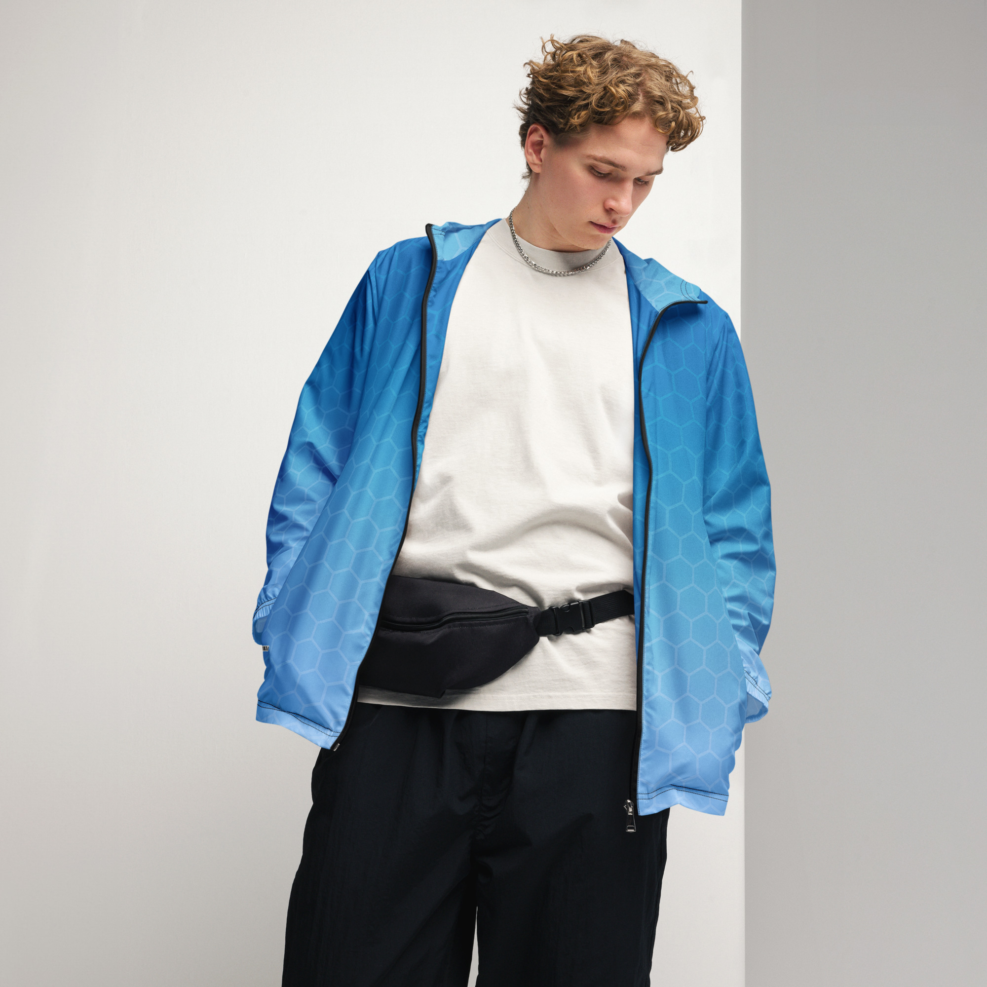 Junger Mann trägt den BERKEI Windbreaker Blue Gear in entspannter Pose