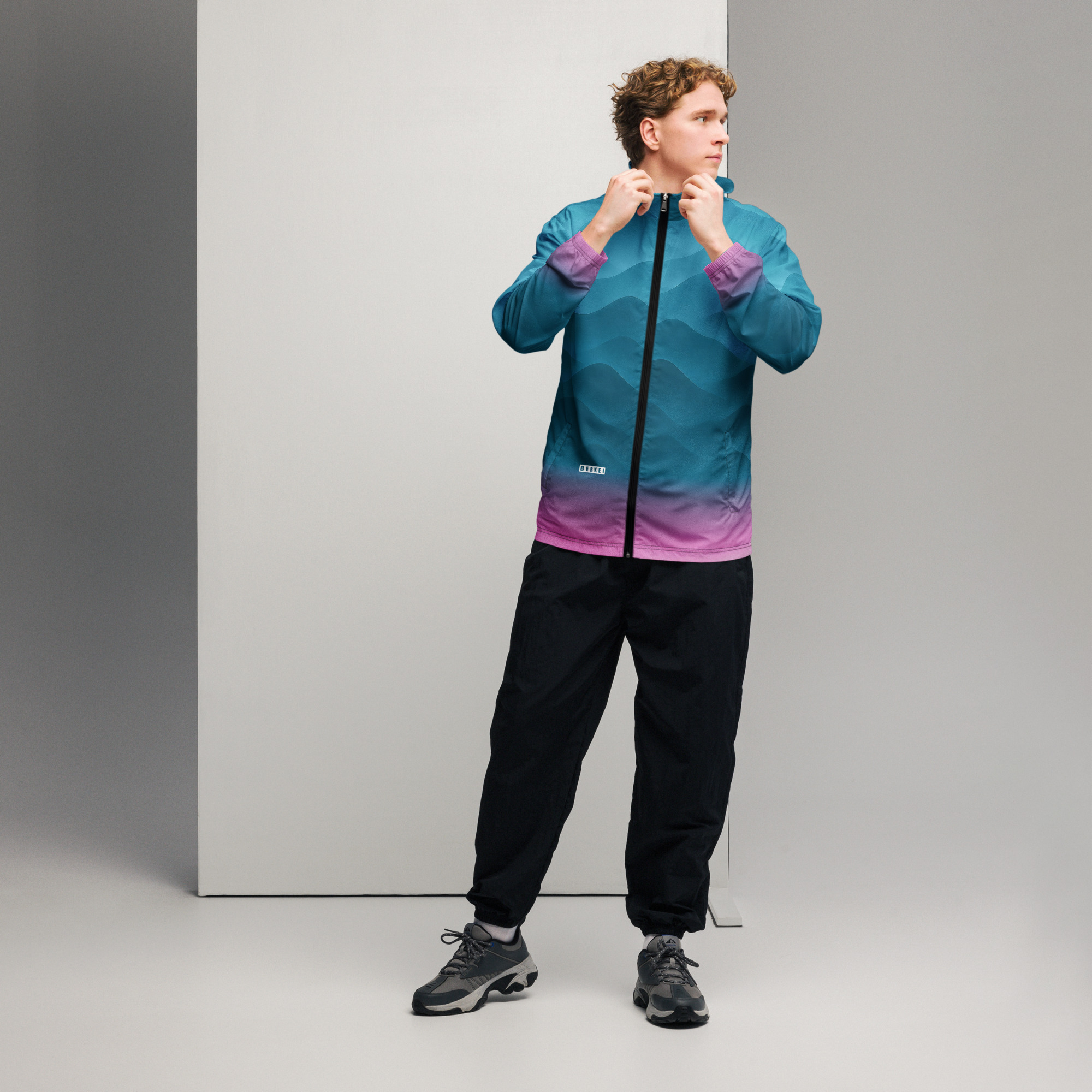 Mann trägt BERKEI Windbreaker in Fountain Blue, stylisch und sportlich für Outdoor-Aktivitäten.