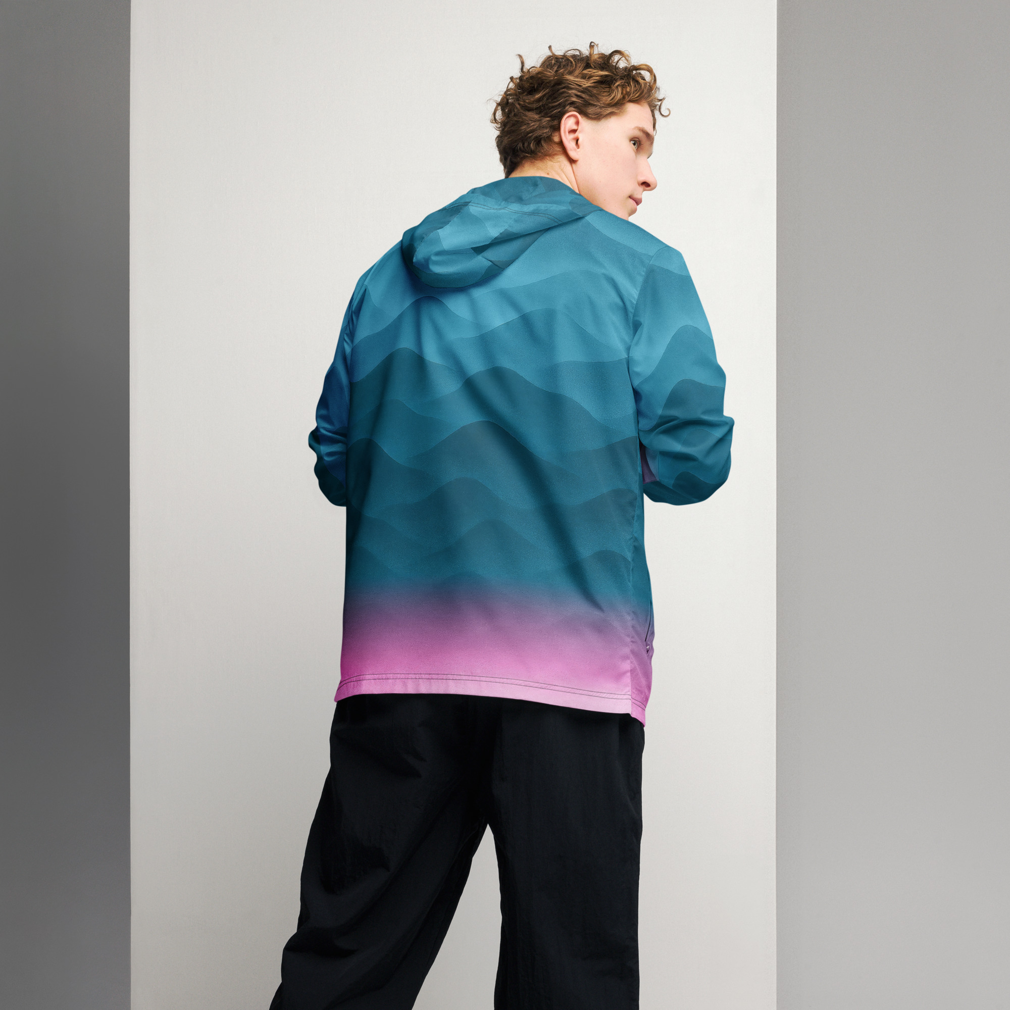 Mann trägt leichtgewichtigen BERKEI Windbreaker in Fountain Blue mit Farbverlauf