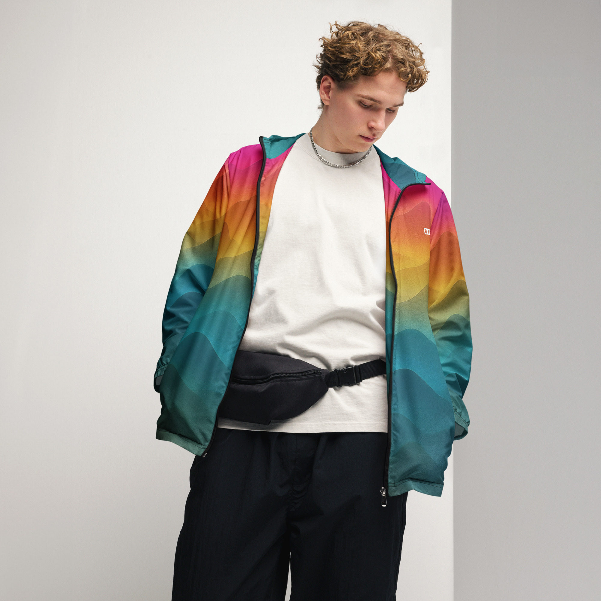 Junger Mann trägt bunten BERKEI Windbreaker Unisex Forest Sunrise im Portrait.