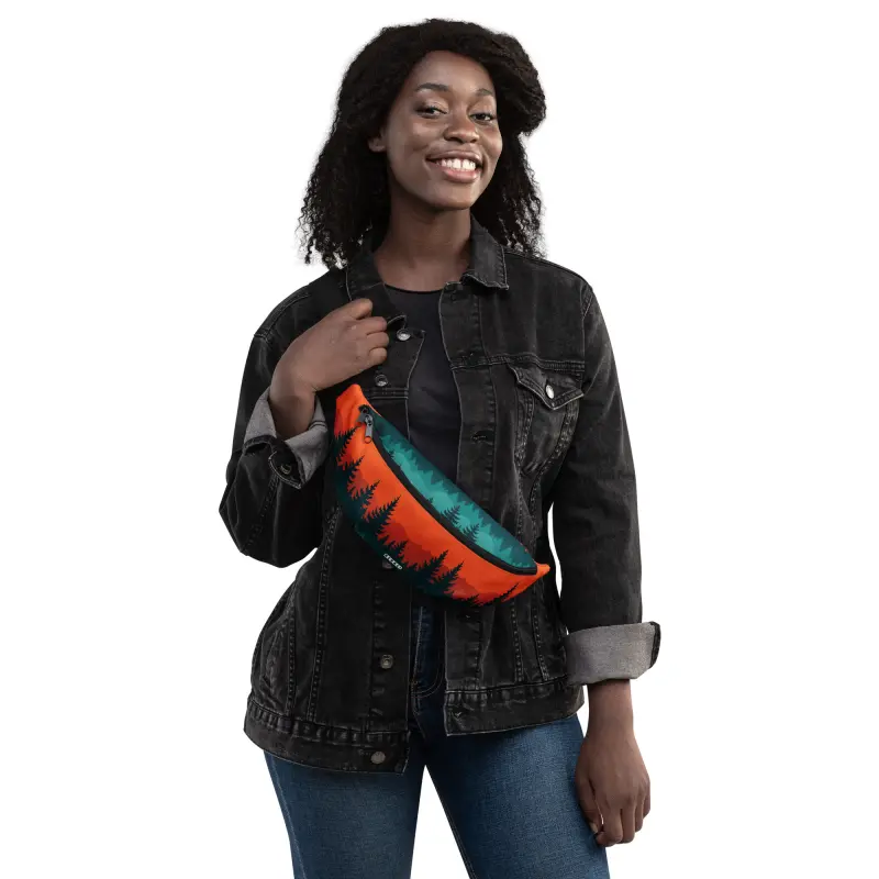Frau trägt BERKEI Hip Pack Taiga Sunset mit Baum-Motiv unter einem schwarzen Jeansjacke